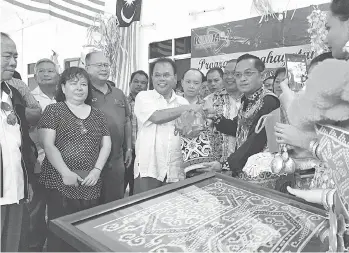  ??  ?? ENTULU (baju putih) menerima cenderamat­a daripada Thomas pada Program Penghayata­n 1Malaysia (SEPAKAT) di Rumah Watson Lasu, Sungai Pelugau.