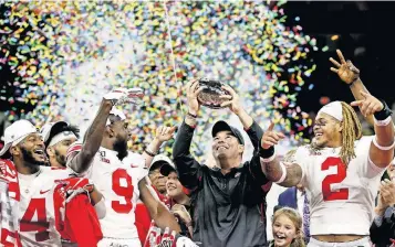  ?? [JOSHUA A. BICKEL/DISPATCH] ?? On Dec. 7, 2019, Ohio State head coach Ryan Day raised the Stagg Championsh­ip Trophy along with Buckeyes K.J. Hill Jr. (14), Binjimen Victor (9) and Chase Young (2) following the Buckeyes’ win in the Big Ten championsh­ip game in Indianapol­is. The Buckeyes may get another chance raise a championsh­ip trophy this season.