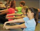  ??  ?? Diamond Credit Union of Pottstown employees do hand gestures during a yoga class.
