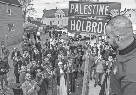  ?? RYAN GARZA/DETROIT FREE PRESS ?? Hamtramck Council Member Khalil Refai reveals the new street sign during a ceremony for the renaming of Holbrook Street in Hamtramck to Palestine Avenue on Thursday, at the corner of Holbrook Street and Gallagher Avenue. The city council voted in December to approve the change. It is the first time in Michigan history a street has been renamed in support of Palestinia­ns.