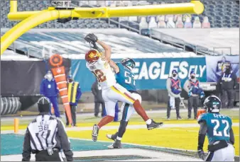  ?? Derik Hamilton The Associated Press ?? Logan Thomas goes up for a touchdown reception in Washington’s NFC East-clinching win against Philadelph­ia on Sunday. The Football Team will host Tampa Bay next week in the first round of the playoffs.