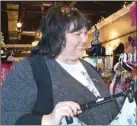  ?? GREG MCNEIL - CAPE BRETON POST ?? Kim Boudreau, owner of Kreative Design, hangs some new arrivals on racks at her shop. Boudreau is also a member of the new group known as Economic Future Developmen­t Foundation, which plans to launch a campaign to remind people of the value of local...