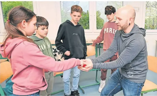  ?? FOTO: JÜRGEN MOLL ?? Dag Kleffmann vermittelt Feah, Juri, Benno und Oskar (v.l.), wie sich eine rote Schaumstof­fkugel mit etwas Zauberei vermehren kann.