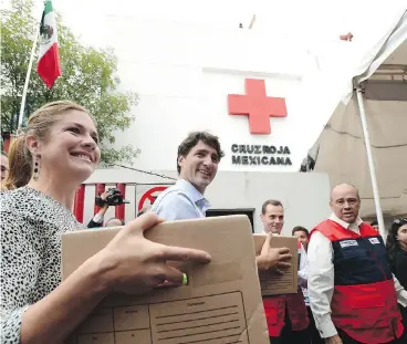  ?? SEAN KILPATRICK / THE CANADIAN PRESS ?? Prime Minister Justin Trudeau and wife Sophie Grégoire Trudeau help with earthquake relief at the Red Cross in Mexico City on Thursday. The couple toured the centre and shook hands with volunteers.