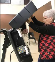  ?? TIMES photograph by Annette Beard ?? Poll worker Winona Wood closes and locks one of the voting machines Tuesday after the polls closed for the special school election. There were 863 votes cast Tuesday at the polling site.