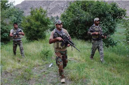  ?? —AFP ?? AFGHANISTA­N: Afghan commando forces patrol at the site of US bombing in the Achin district of Nangarhar province.