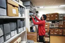  ?? Jon Shapley / Staff photograph­er ?? Sheena Wilson, assistant manager and lead archivist, pulls an item at the African American Library at the Gregory School in Fourth Ward.