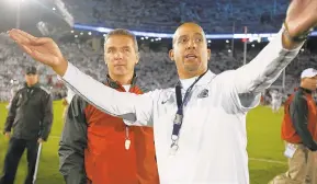  ?? GENE J. PUSKAR / AP ?? Penn State coach James Franklin, right, shows Ohio State coach Urban Meyer the student section at Beaver Stadium prior to their 2014 game.