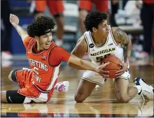  ?? PAUL SANCYA — THE ASSOCIATED PRESS ?? Michigan guard Eli Brooks (55) tries to pass under pressure from Illinois guard Andre Curbelo (5)in the first half in Ann Arbor Tuesday.