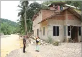  ??  ?? MUHAMAD BUDI/JAWA POS RADAR PACITAN MENGUNGSI: Aliran anak Sungai Grindulu menggerus permukaan tanah rumah Musahidin di Dusun Wonosari, Desa Karangrejo.