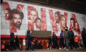  ?? Photograph: Phil Noble/Reuters ?? Fans walk past a graphic at Anfield displaying Mohamed Salah, Virgil van Dijk and Andy Robertson – three signings from Michael Edwards’ first spell.