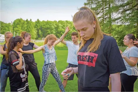  ?? FOTO: BECKER&BREDEL ?? Jugendlich­e üben auf dem Sportplatz im lothringis­chen Spichern für das Stück „Fara voce – ohne Stimme".
