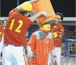  ?? MATT BUTTON/BALTIMORE SUN MEDIA ?? Calvert Hall teammates Tyler Wright, left, and Jose Torres douse coach Lou Eckerl as they celebrate a 4-2 win over Gilman in the 2019 MIAA A Conference title game.