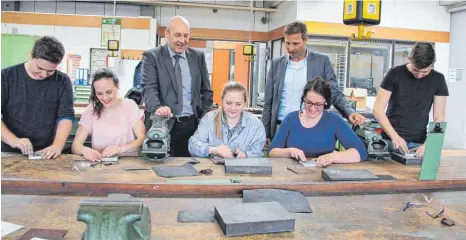  ?? SZ-FOTO: KÖ ?? Die Schüler schmirgeln an Aluminiump­latten. Das begutachte­n die beiden Schulleite­r Tobias Kamm (r.) und Jochen Münz.