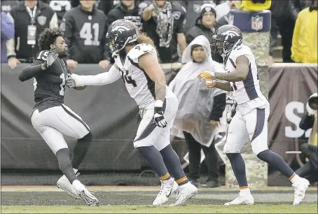  ?? BEN MARGOT – THE ASSOCIATED PRESS ?? Raiders wide receiver Michael Crabtree, left, fights with Denver Broncos nose tackle Domata Peko, center, and cornerback Aqib Talib during the first half of Sunday’s game at the Coliseum. Crabtree and Talib were ejected from the game.