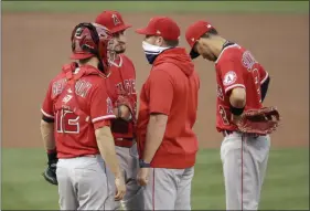  ?? BEN MARGOT - THE ASSOCIATED PRESS ?? Los Angeles Angels pitcher Andrew Heaney, second from left, speaks with pitching coach Mickey Callaway, second from right, in the first inning of a baseball game against the Oakland Athletics Friday, Aug. 21, 2020, in Oakland, Calif.