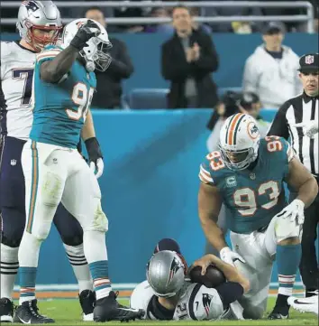  ?? Mike Ehrmann/Getty Images ?? The Miami Dolphins sacked Tom Brady twice Monday night and also intercepte­d him twice. Can he be expected to have two such games in a row?