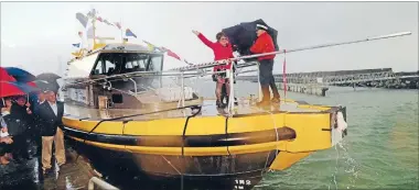  ?? Photo: ROBERT CHARLES/FAIRFAX NZ ?? Smashing time: A burst of heavy rain doesn’t stop Rel Squire from christenin­g Port Taranaki’s new pilot boat Mikotahi yesterday. Mikotahi is 19.5 metres long and almost 6m wide with a 1m draft. It weighs 27,000kg.