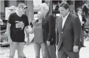  ?? EVAN VUCCI AP ?? President Joe Biden talks with people affected by Hurricane Ian as he tours Fort Myers Beach. Florida Gov. Ron DeSantis walks by at right.