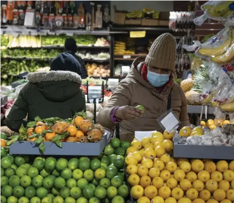  ?? Bloomberg ?? Shoppers at a fruit market in New York. Higher interest rates are expected to remain a burden for US consumers next year