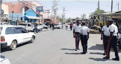  ?? FILE ?? Police on foot patrol along Sevens Road, May Pen, Clarendon.