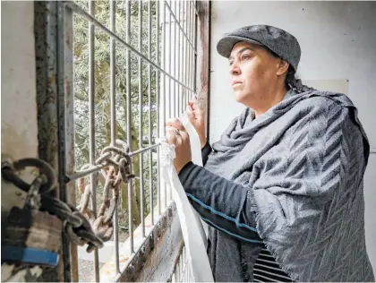  ?? Photo / NZME ?? Ali Beal, manager of the old Napier Prison, checks the wall where people have tried to break into the prison.