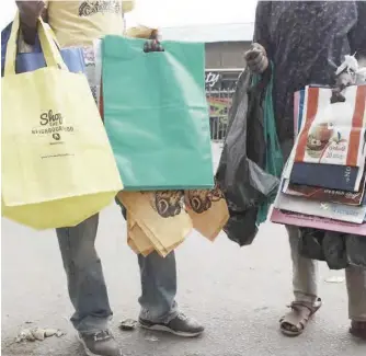  ??  ?? FILE PHOTO: Vendors sell reusable eco-friendly carrier bags