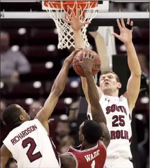  ?? McClatchy Newspapers/C. MICHAEL BERGEN ?? South Carolina’s Brian Richardson (2) and Mindaugas Kacinas block a first-half shot by Arkansas’ Mardracus Wade in the Razorbacks’ 75-54 loss Saturday in Columbia, S.C. Wade missed all six of his shots from the field, getting his only points on two free throws.