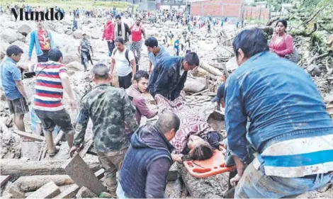  ?? FOTO: AFP ?? ►► Personas ayudan a transporta­r a una mujer tras la avalancha, en Mocoa, departamen­to de Putumayo.