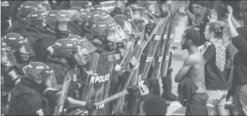  ??  ?? Police officers in riot gear approach demonstrat­ors in downtown Charlotte, NC.