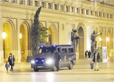  ?? ÁNGEL DE CASTRO ?? Agentes de la Policía Nacional, en la plaza del Pilar de Zaragoza vigilando por la noche para evitar las reuniones.