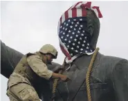  ?? AFP ?? The US flag covered Saddam’s head on the statue