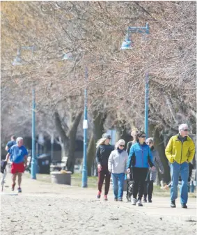  ?? PETER J. THOMPSON / NATIONAL POST ?? Walkers take in the sunshine on Toronto’s Beaches boardwalk on Thursday.