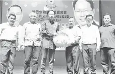  ??  ?? Chin (third right) presenting a souvenir to Teo while Tham (left), Lee (second right) and others look on.