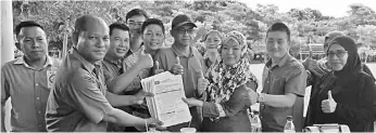  ??  ?? Asroh (left) receiving membership forms in Pensiangan.