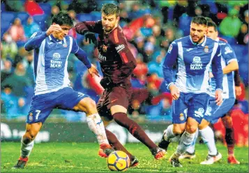  ??  ?? Barcelona's Gerard Pique (C) vies with Espanyol's Gerard Moreno (L) during their La Liga match.