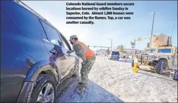  ?? ?? Colorado National Guard members secure locations burned by wildfire Sunday in Superior, Colo. Almost 1,000 houses were consumed by the flames. Top, a car was another casualty.