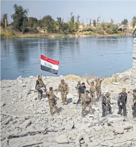 ??  ?? Las fuerzas especiales iraquíes celebraban ayer su llegada a las márgenes del río Tigris, en Mosul