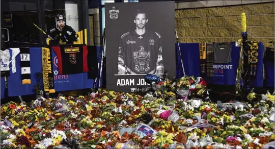  ?? AP ?? Flower tributes for Nottingham Panthers player Adam Johnson rest outside the Motorpoint Arena before a Nov. 18 memorial ice hockey game. Import hockey players like Johnson in the United Kingdom don’t earn big salaries but the perks are pretty good. They get free use of a car and rent-free housing, plus they can also earn a master’s degree tuition-free.