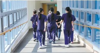  ?? Yonhap ?? Nurses walk down a hallway in a major hospital in Incheon, Thursday.