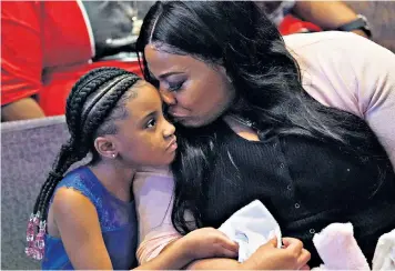  ??  ?? Roxie Washington holds Gianna Floyd, her daughter with George Floyd as they attend his funeral service, at The Fountain of Praise church in Houston. Actors Channing Tatum, back left, and Jamie Foxx, far right, were among celebritie­s paying their respects