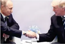  ??  ?? US President Donald Trump and Russia’s President Vladimir Putin shake hands during a meeting on the sidelines of the G-20 Summit in Hamburg, Germany, on Friday. (AFP)