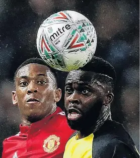  ?? PHOTO: REUTERS ?? Two heads are better than one . . . Manchester United’s Anthony Martial (left) and Burton Albion’s Hope Akpan compete for a header during an English League Cup thirdround match at Old Trafford in Manchester yesterday. United won 41.