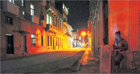  ?? REUTERS ?? A media luz. Una mujer en La Habana, con su celular. La isla sufre apagones diarios y en algunos casos llegan a las 13 horas seguidas.