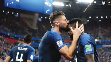  ??  ?? GETTY IMAGES France’s Olivier Giroud (L) kisses Samuel Umtiti on the head celebratin­g the winner against Belgium at the 2018 World Cup semifinal in Saint Petersburg Stadium in Saint Petersburg, Russia, on July 10, 2018.