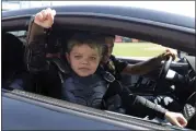  ?? ERIC RISBERG — ASSOCIATED PRESS FILE ?? In this file photo from Tuesday, April 8, 2014, Miles Scott, dressed as Batkid, gestures as he sits in the Batmobile after throwing the ceremonial first pitch before a baseball game between the San Francisco Giants and the Arizona Diamondbac­ks in San Francisco.