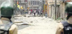  ?? WASEEM ANDRABI/HT PHOTO ?? Protesters throw stones at police in Srinagar on Sunday to vent anger against the killing of Hizbul Mujahideen commander Burhan Wani.