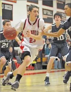  ?? CATHERINE AVALONE/THE MIDDLETOWN PRESS ?? Cromwell senior forward Kevin Francis drives through Immaculate’s defense of Shane Raymond (21), Nick Gerbo (10) and Joey Wallace (22).