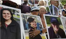  ?? Photograph: José Luis Magaña/AP ?? Victims’ families hold pictures of loved ones outside the transport department in Washington.