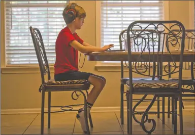  ?? (Arkansas Democrat-Gazette/Stephen Swofford) ?? Eli Beasley, 11, attends his English class Oct. 2 in the dining room of his family’s home in Sherwood. Michele Beasley, Eli’s mother, said the sixth-grader and her other son, fourth-grader Ethan, struggle to keep up with their virtual curriculum at LISA Academy Public Charter Schools. “The pressure is just too much. I can’t figure out how to manage this and work.”